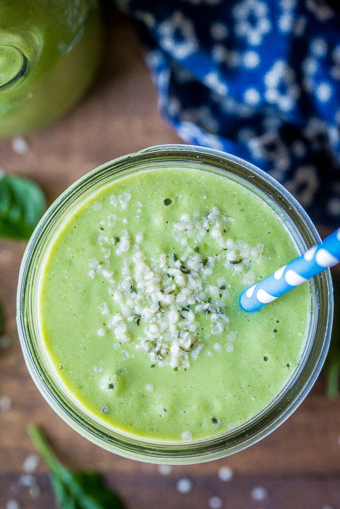 close up of a green smoothie in a cup with hemp hearts on top