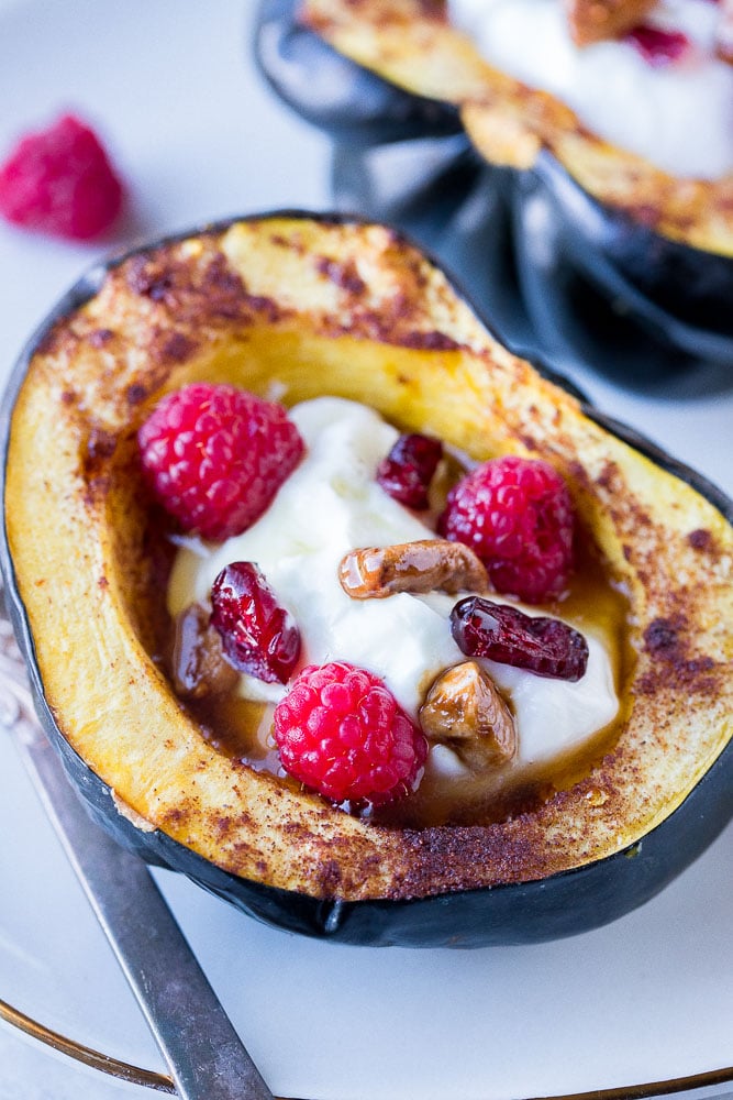 close up of a roasted acorn squash with yogurt and berries