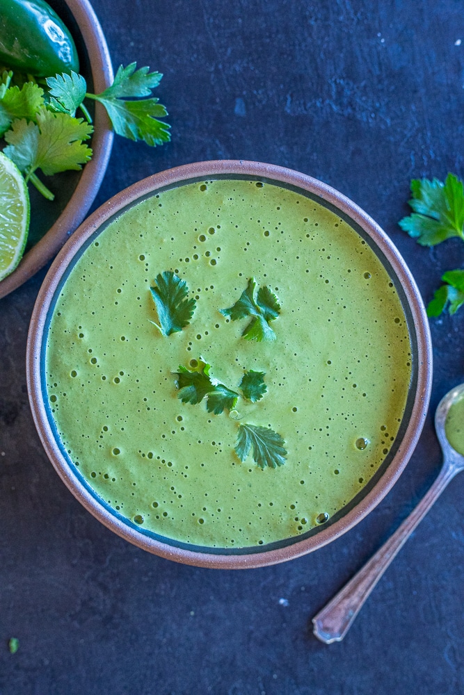 flatlay photo of a bowl of green tahini sauce 
