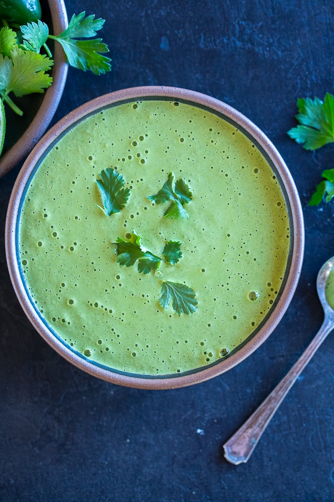 bowl of green tahini sauce topped with cilantro