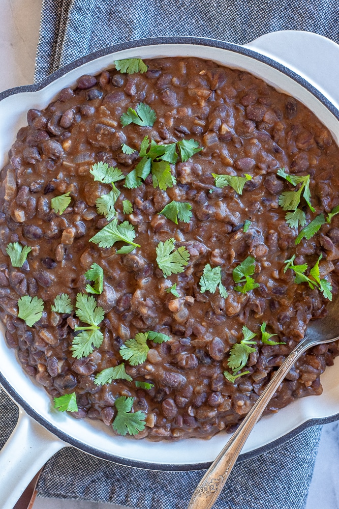 big pan of Mexican black beans with cilantro on top