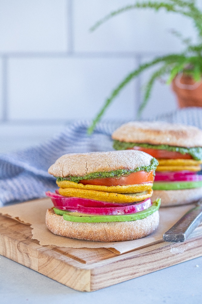 vegan breakfast sandwiches on a cutting board with a fern in the background