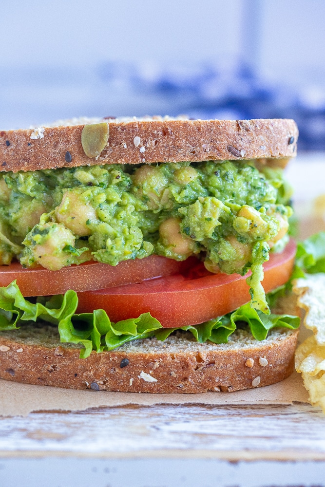 Close up of an avocado pesto chickpea sandwich