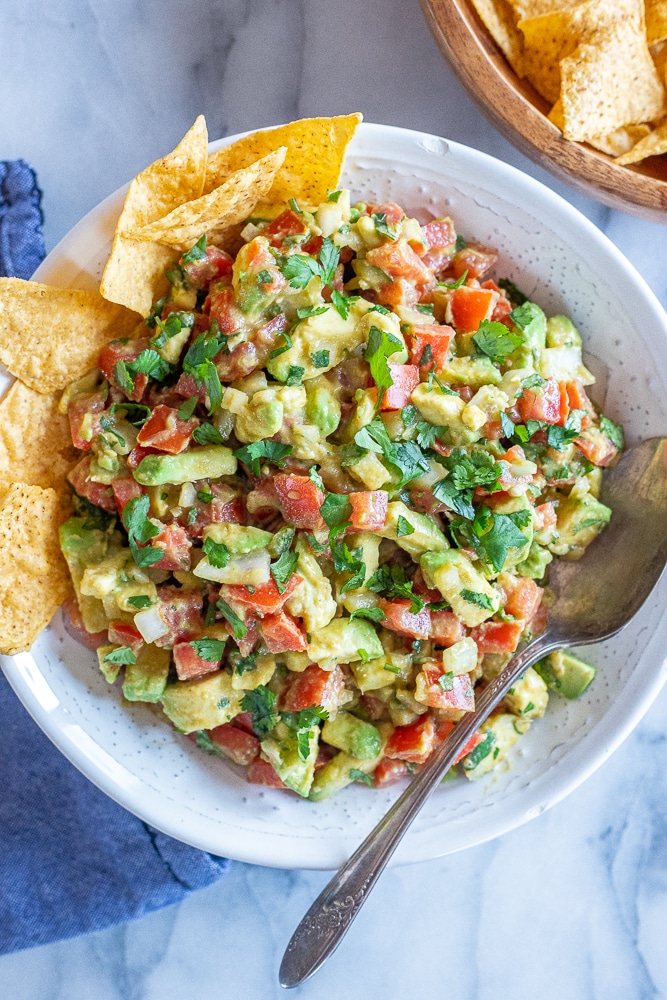 chunky avocado salsa in a bowl with chips