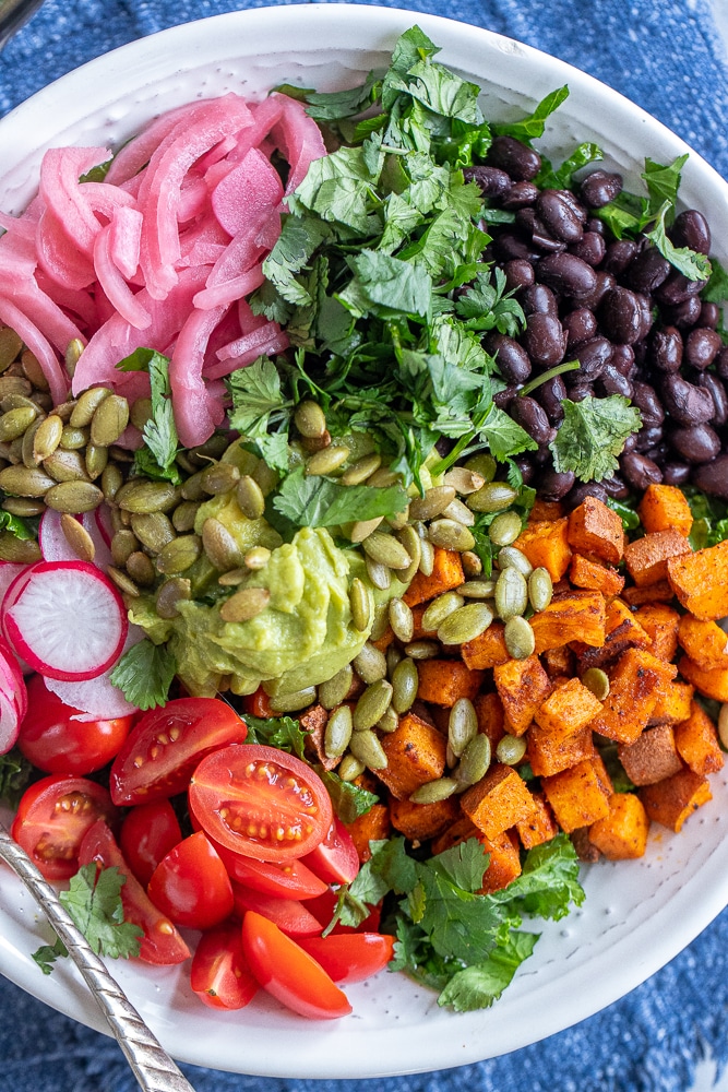 close up of a big bowl of roasted sweet potato and black bean kale salad