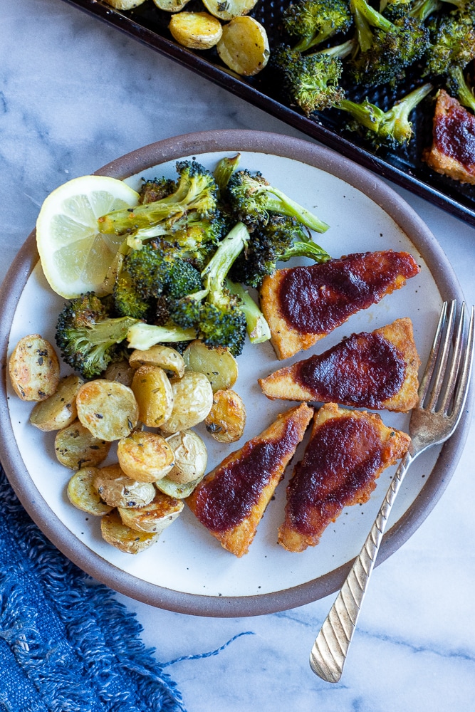 BBQ tofu, roasted potatoes and broccoli on a plate with a fork