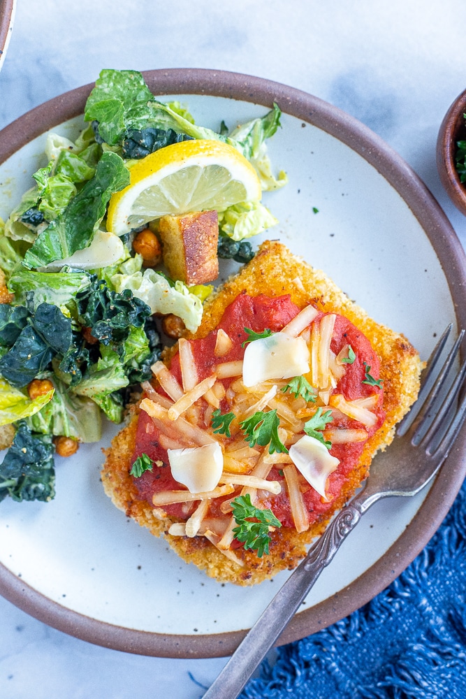 vegan tofu parmesan on a plate with a salad