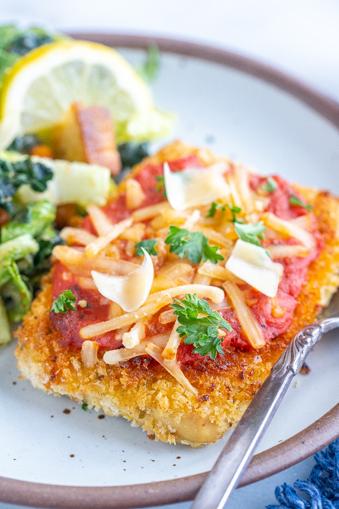 close up of a crispy piece of tofu parmesan on a plate