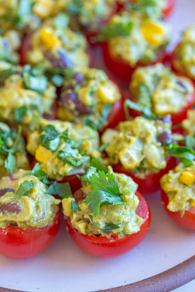 guacamole stuffed tomatoes on a plate