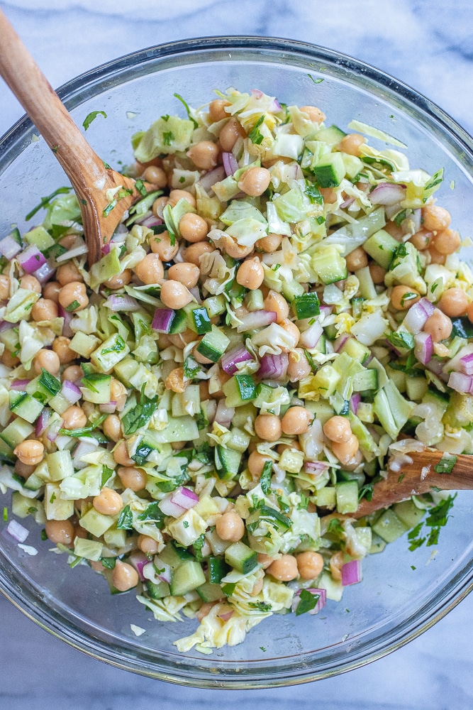 the best chickpea salad mixed up in a bowl with dressing