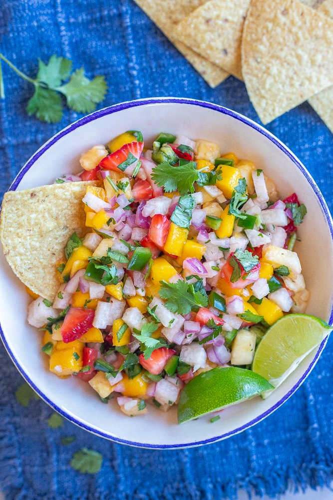 fresh fruit salsa in a bowl with chips and limes