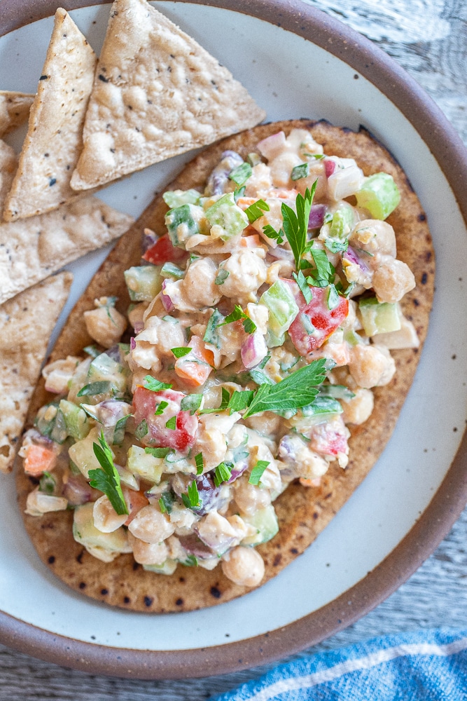 lemon tahini chickpea salad on a pita with some chips