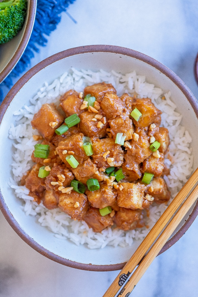 a bowl of peanut butter tofu with rice and broccoli