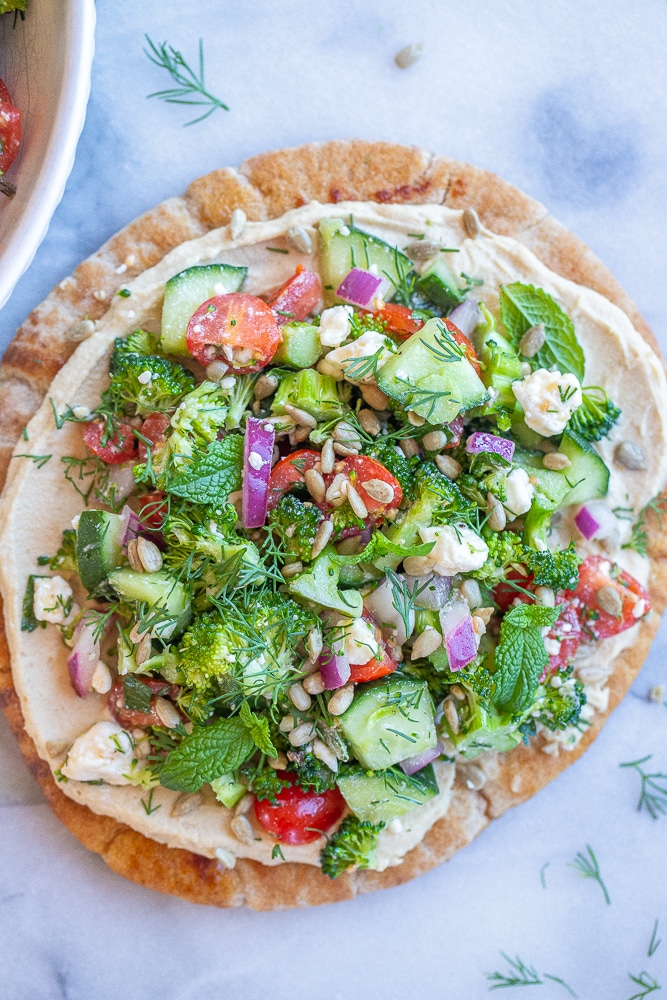 broccoli salad hummus pitas on a cutting board