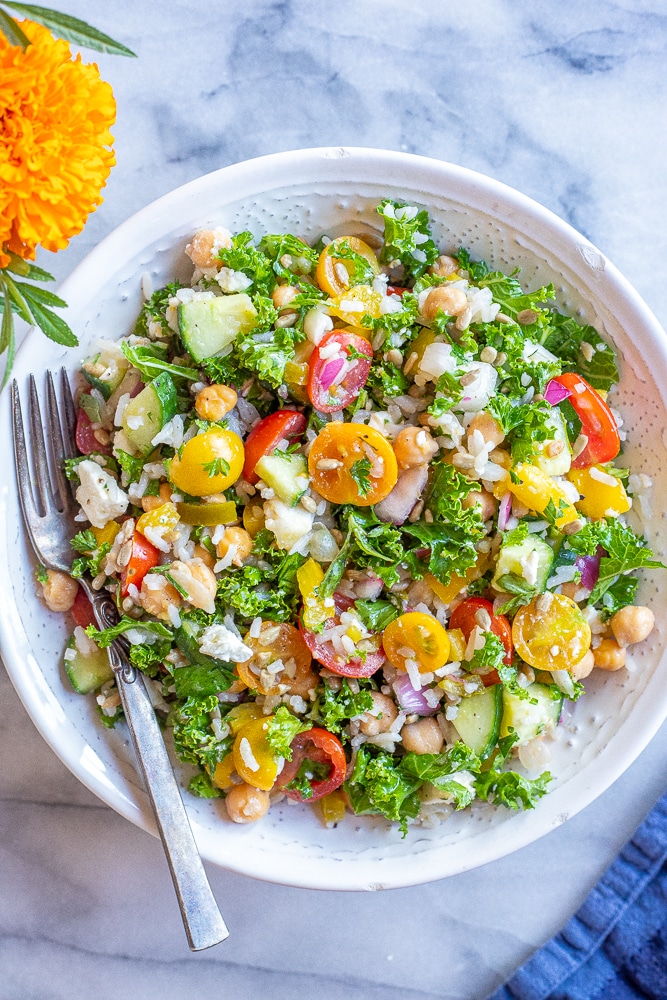 rice salad with chickpeas and kale in a bowl with lots of vegetables