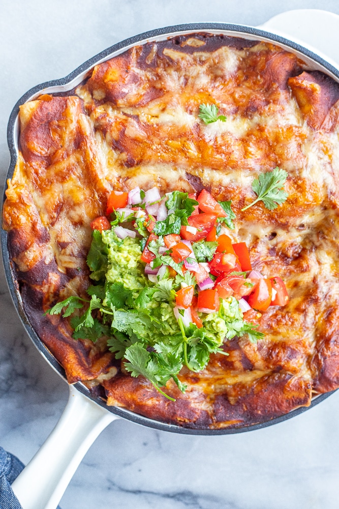 close up of a pan of cheesy zucchini enchiladas