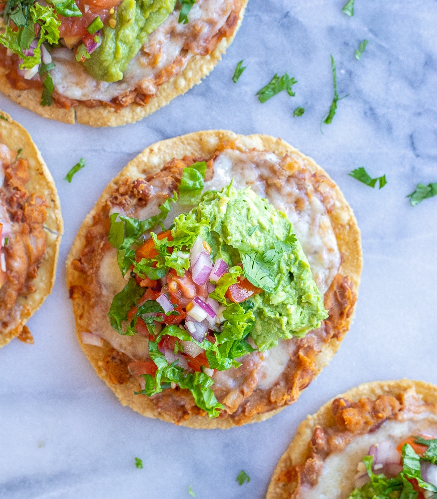 bean and cheese tostadas on a marble cutting board