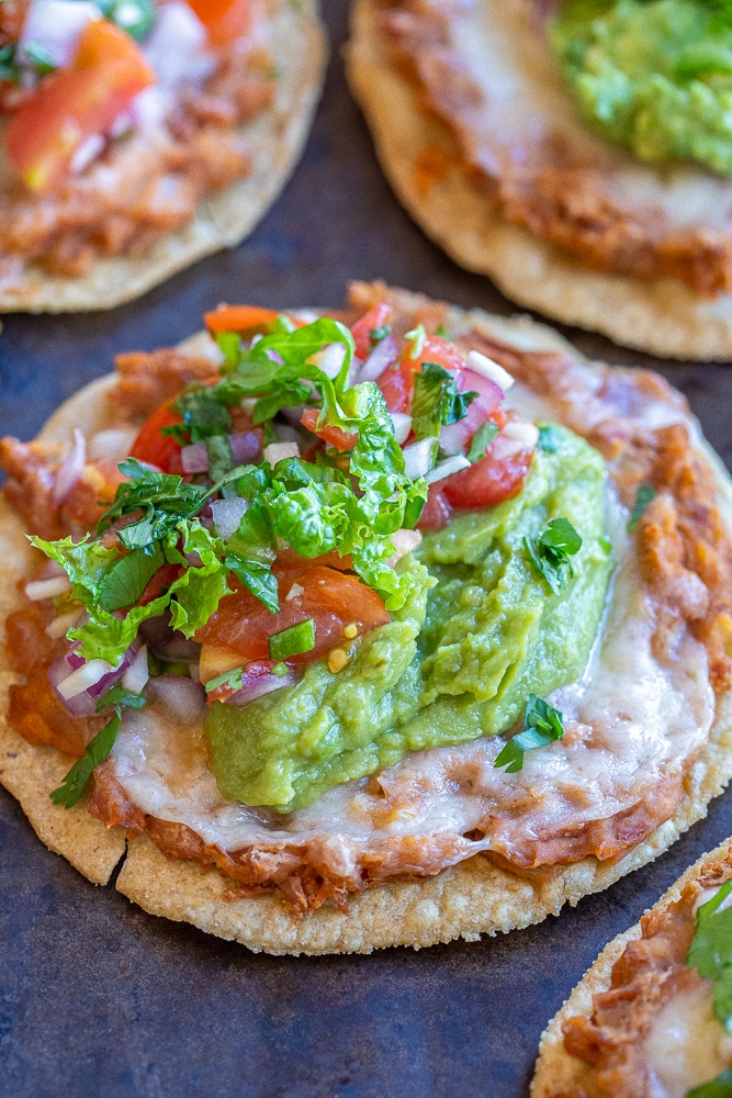 close up view of bean and cheese tostadas with toppings