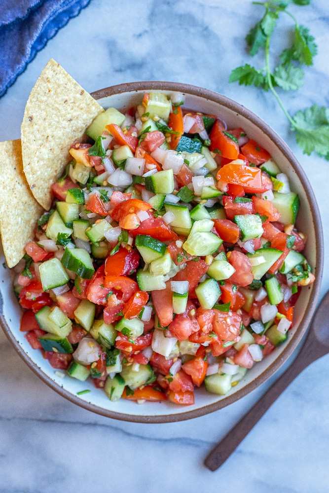 big bowl of chunky cucumber salsa with chips