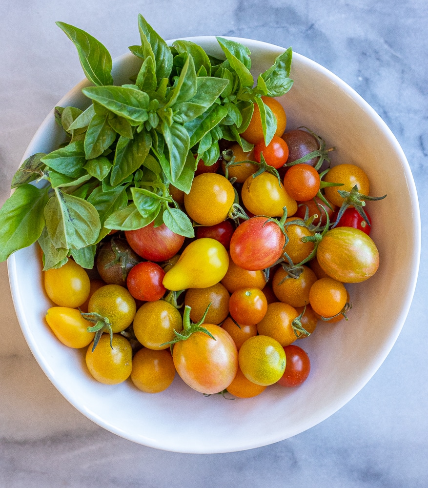 fresh cherry tomatoes and basil in a bowl