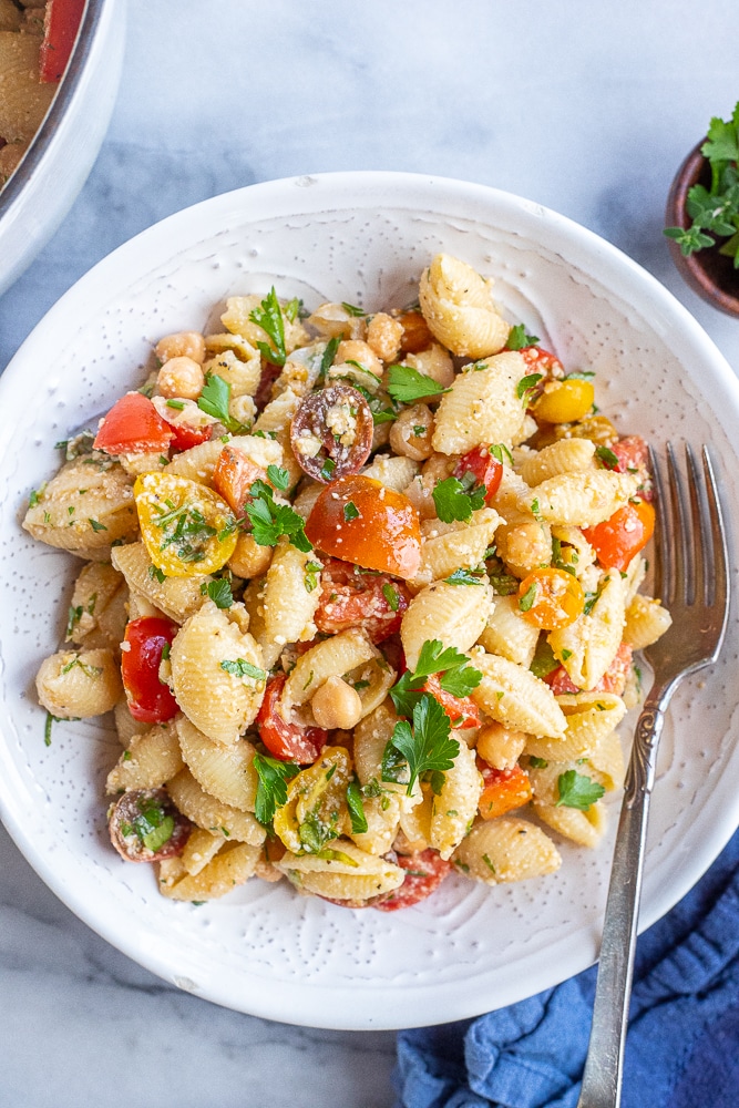 dinner table with a bowl of tomato pasta with parmesan and herbs