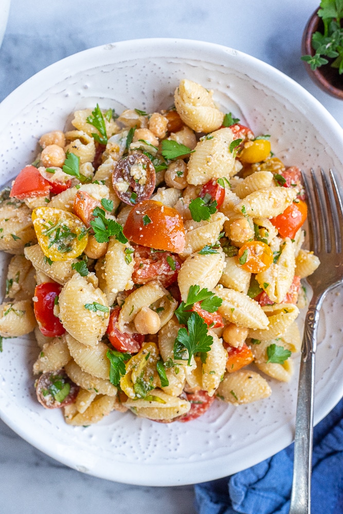 bowl of herby parmesan Tomato Pasta Salad with a fork