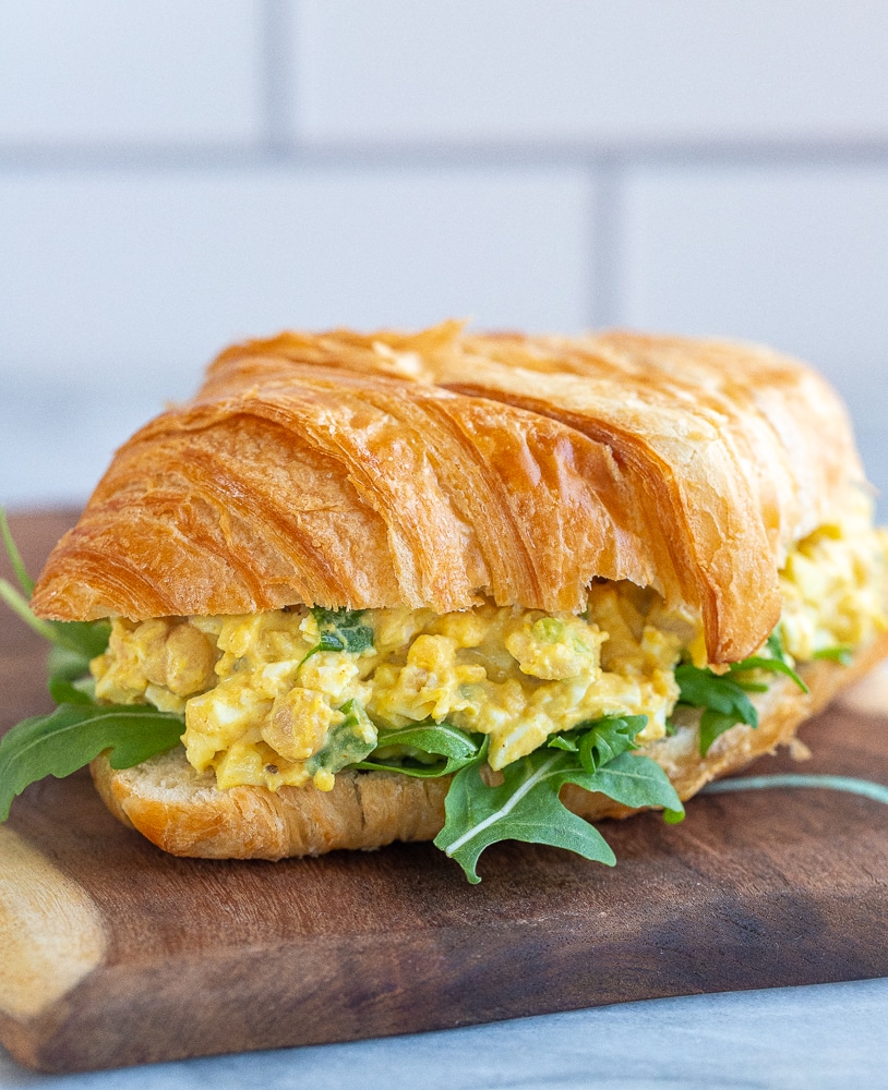 curried egg salad with chickpeas on a croissant