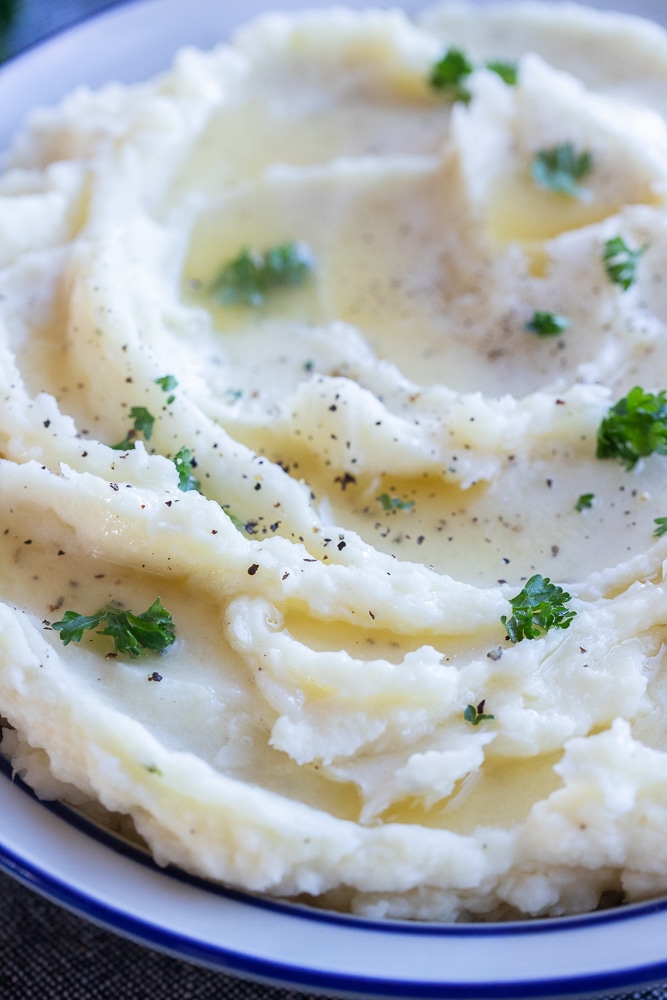 close up of a bowl of silky mashed potatoes with butter