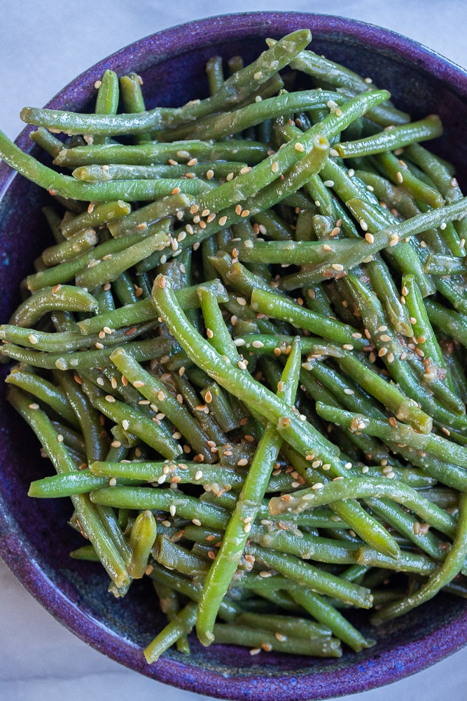 purple bowl full of miso sesame green beans