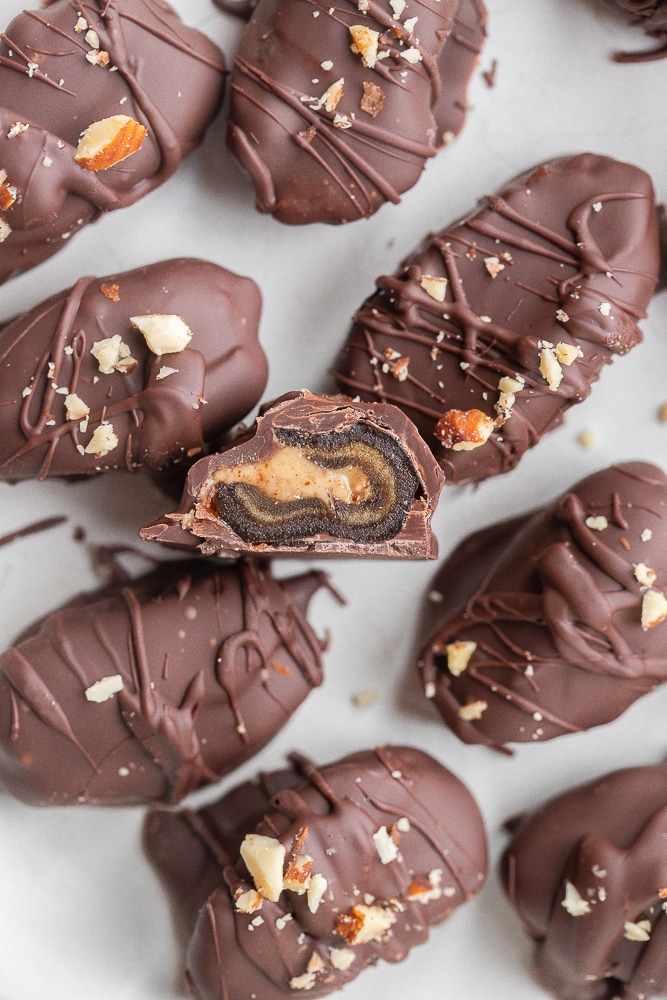plate of chocolate covered smoky almond butter stuffed dates with one cut in half
