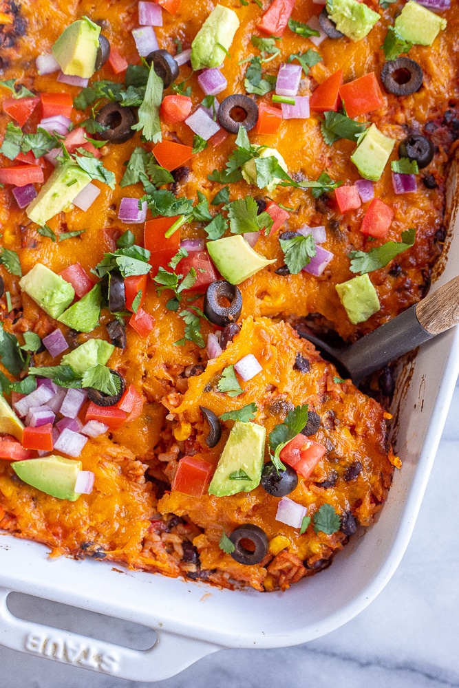 close up of rice and bean taco casserole in a dish with a spoon