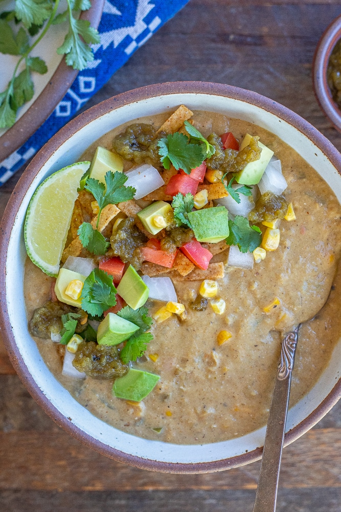 a bowl of creamy vegetarian white bean chili with lots of toppings