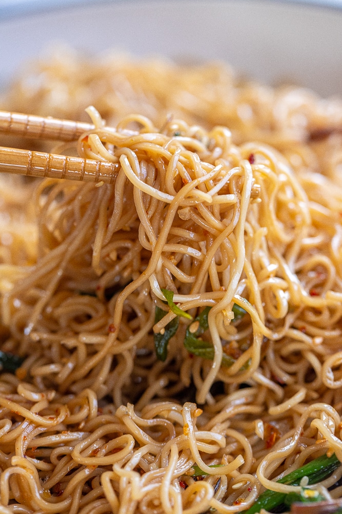 close up of scallion noodles with chopsticks