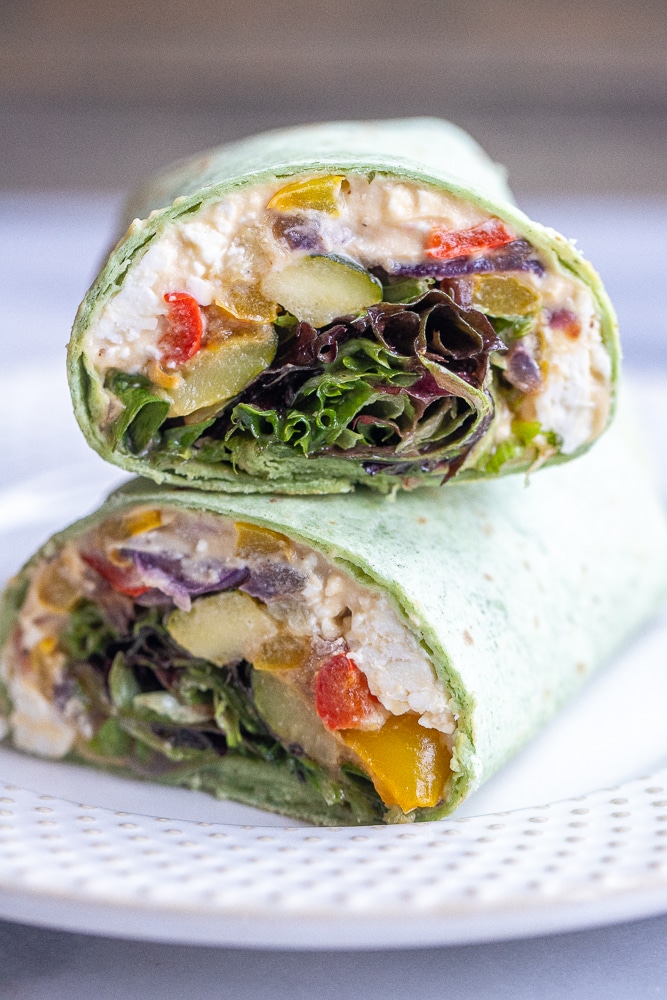 roasted veggie hummus wraps stacked on top of each other