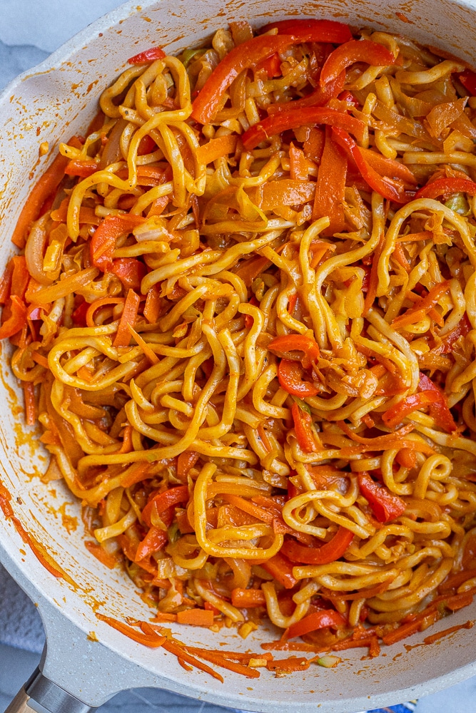 close up of red curry noodles in a pan 