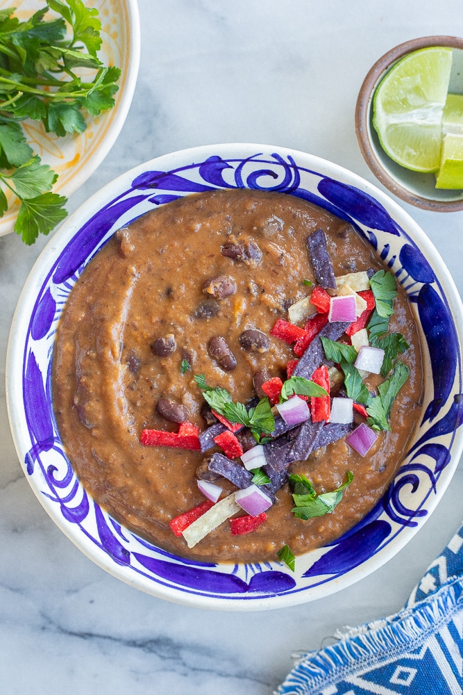 creamy black bean and sweet potato soup in a bowl with toppings