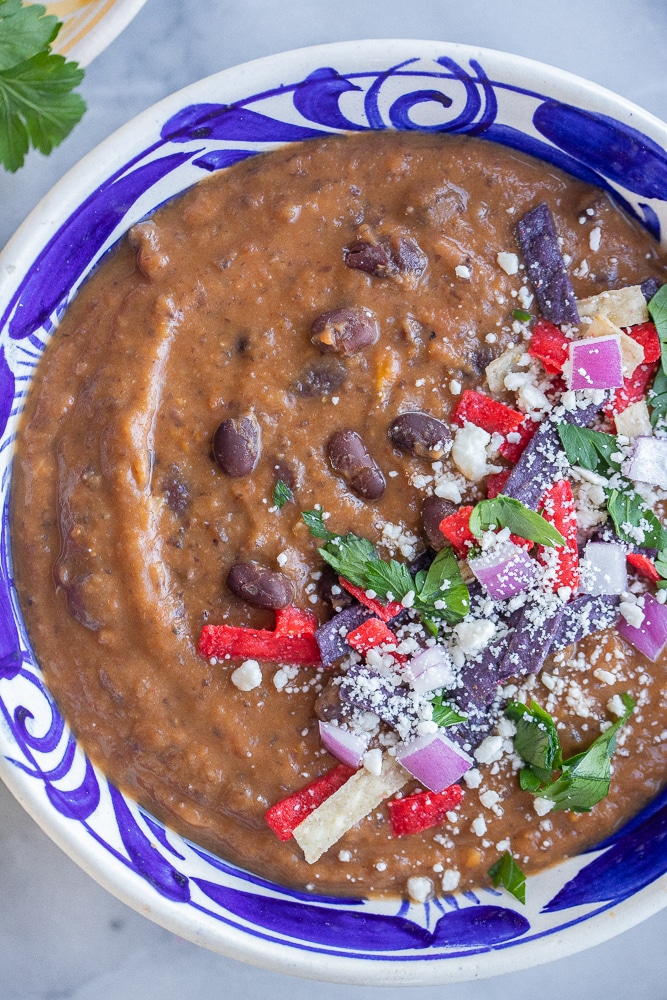 close up of easy black bean soup in a bowl with toppings