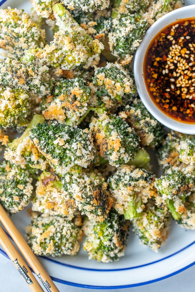 crispy baked broccoli on a plate with spicy soy sauce