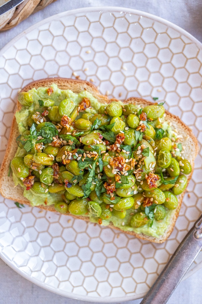 close up of asian style avocado toast with garlic ginger edamame