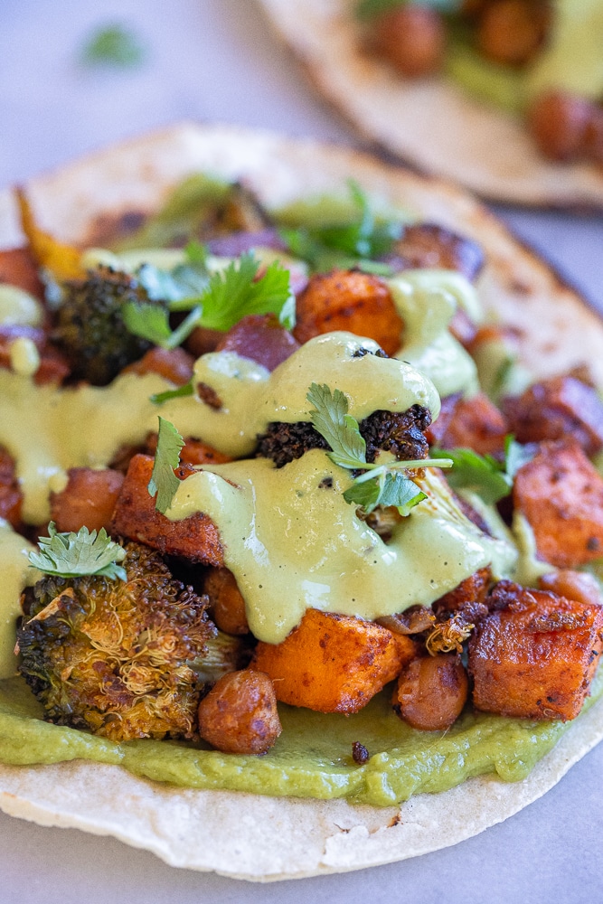 close up photo of a roasted vegetable taco with cilantro lime cream sauce