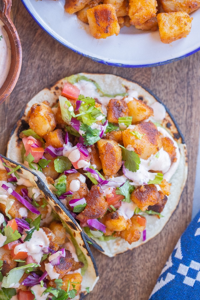 close up of a crispy potato taco with spicy ranch dressing