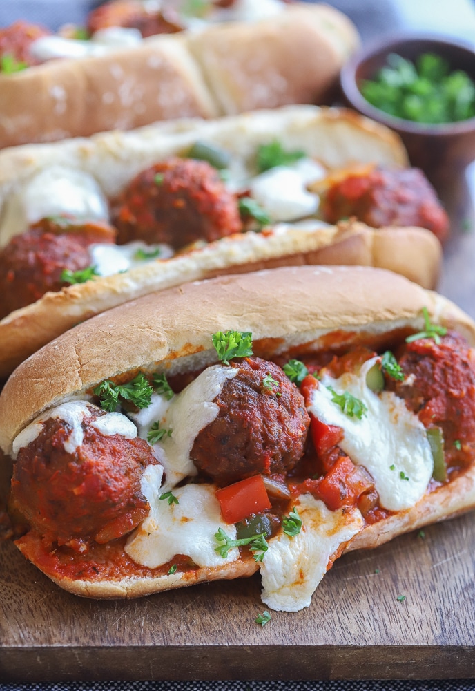 close up of a vegetarian meatball sub with veggies and mozzarella cheese