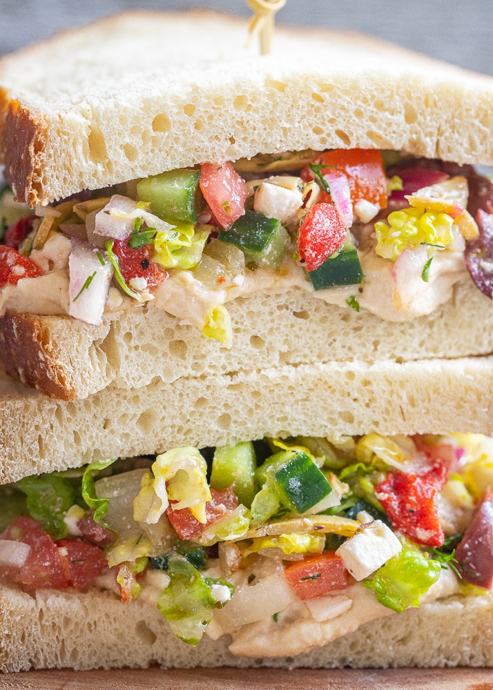 close up of a greek salad sandwich on sourdough bread