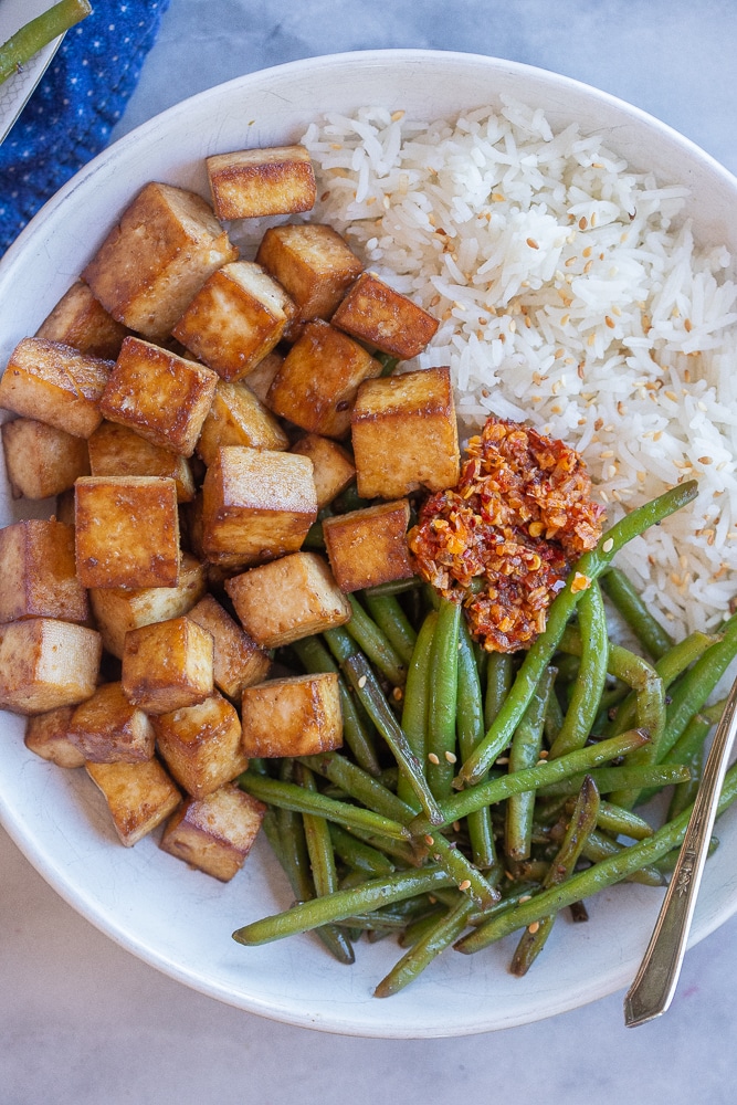 easy pan fried tofu in a bowl with rice and green beans