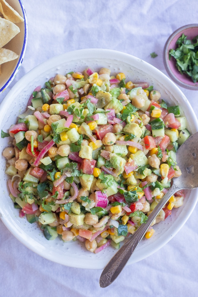 pickled onion and avocado salad in a serving bowl with a side of corn chips