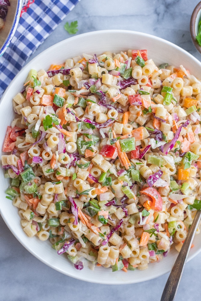 large bowl of macaroni coleslaw salad with a serving spoon