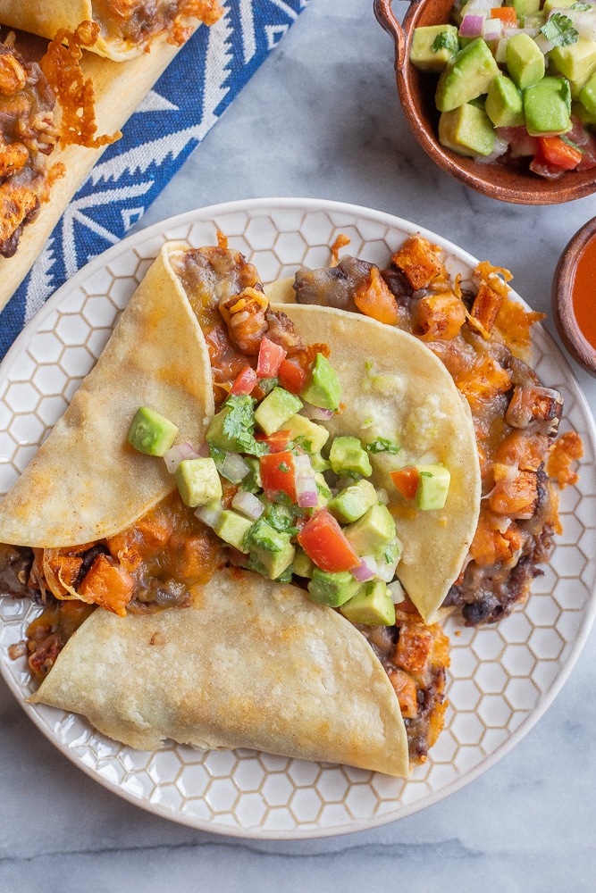 a plate of crispy baked tacos with sweet potato and black beans