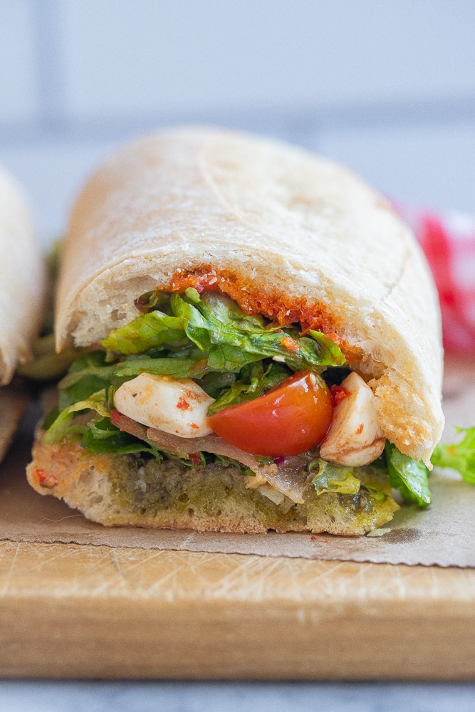 close up of a caprese salad sandwich that has been sliced in half