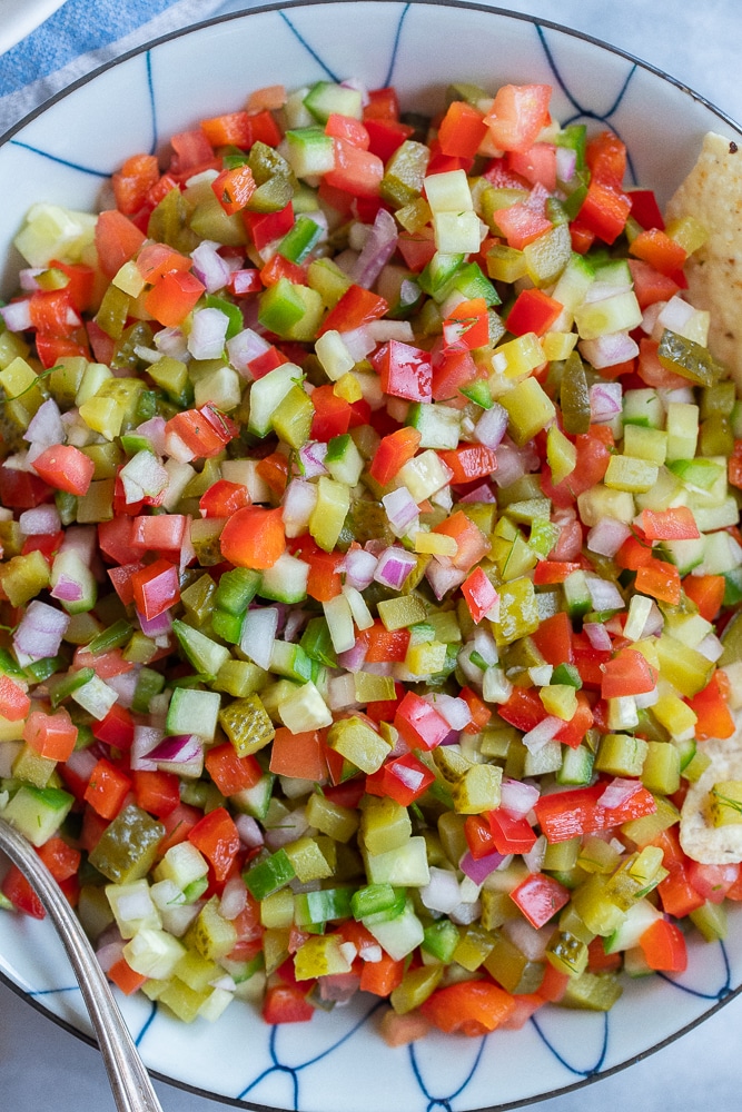 large bowl of pickle de Gallo with a serving spoon and chips