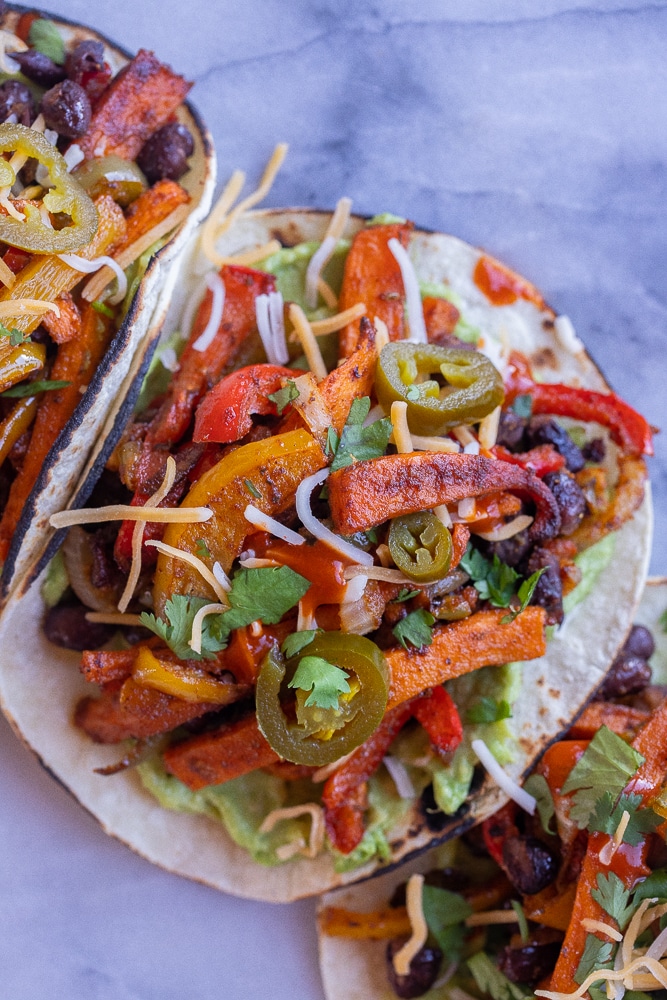 close up of a sweet potato and black bean fajita with toppings